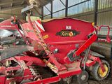un tracteur rouge garé sur la terre battue