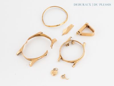 trois bagues en or et une paire de boucles d'oreilles posées sur un fond blanc