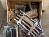 a cardboard box filled with assorted items sitting on the ground