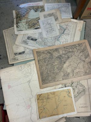 de nombreuses cartes anciennes jonchent le sol de cette pièce