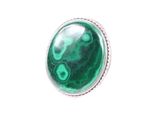 un gros plan d'une bague en pierre verte sur fond blanc