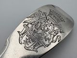 a silver spoon with a coat of arms and a crown on it