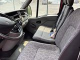 the interior of a red van with grey seats and a black steering wheel