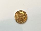 a close up of a gold coin on a white surface