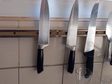 a lot of knives hanging on the wall in the kitchen