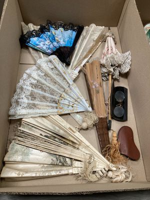a cardboard box filled with assorted items like umbrellas, hats, and other items
