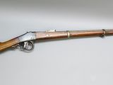 un vieux fusil avec un canon en bois et une poignée en métal