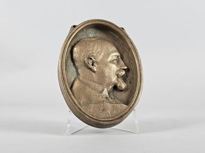 an antique bronze portrait of a man with a beard and mustache