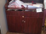 a desk with a book shelf and a chair in the corner