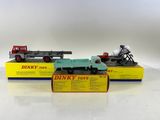 Deux camions Dinky Toys sont exposés sur une surface blanche