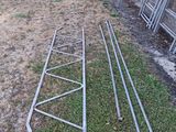 several metal ladders leaning against a brick wall in a yard
