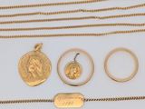 une collection de bijoux en or comprenant une pièce de monnaie, une bague et un collier