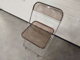 a clear plastic chair sitting in front of a garage door