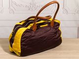 brown and yellow handbag on a table with a wall in the background