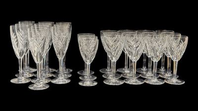 douze verres à vin en cristal alignés sur un fond noir