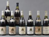 several bottles of wine are lined up on a glass shelf