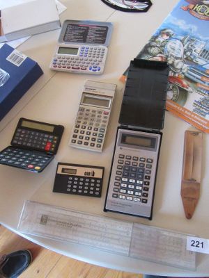 une table sur laquelle sont posées de nombreuses calculatrices