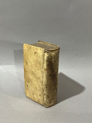 an old book sitting on top of a white table next to a cup of coffee