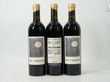 three bottles of wine sitting on top of a white table