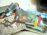 une pile de cartes postales posée sur un bureau, à côté d'un ordinateur portable