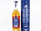 a bottle of whisky in front of a blue box