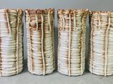 quatre vases sont alignés sur une surface grise