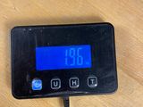 a digital clock on a table with a charger