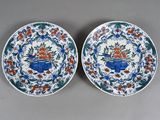 two blue and white plates with floral designs on them sitting on a table