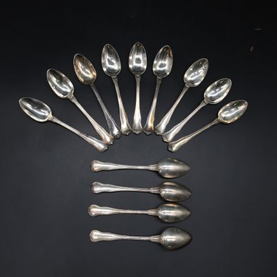 six silver spoons arranged in a circle on a black surface