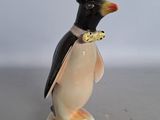 une figurine représentant un pingouin portant un haut-de-forme et un nœud papillon