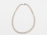 a close up of a necklace on a white surface
