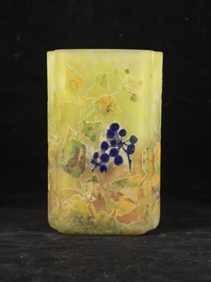 a close up of a yellow vase with blue flowers on it