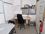 a desk with a chair and a whiteboard in a room