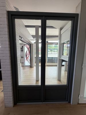 une double porte noire avec une vitre à l'extérieur