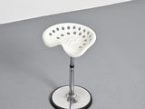 a white stool sitting on top of a gray floor