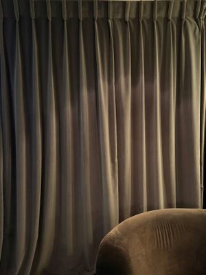 curtains in a living room with a chair and a lamp