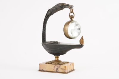 une horloge posée sur un socle sur lequel est perché un oiseau