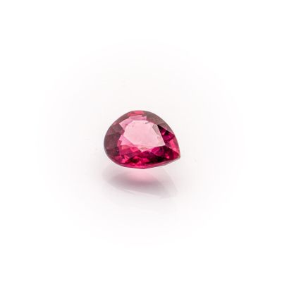 a close up of a pink tourmaline gemstone on a white surface