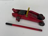 a red jack and a pencil on a white surface