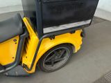 a yellow scooter with a black box on the back of it