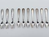 a group of silver spoons and spoon spoons on a white surface
