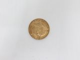 a close up of a gold coin on a white surface