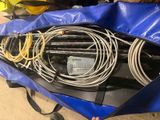 un sac bleu rempli de câbles, éparpillés par terre