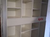 a white book shelf with a red sign on it