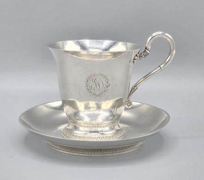 a silver cup and saucer on a saucer on a saucer