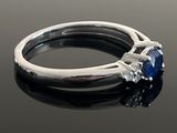 a close up of a ring with a sapphire and diamonds