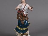 an antique figurine of a woman holding a dog