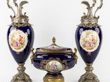 deux vases bleus avec des anses dorées et un couvercle orné de l'effigie d'une femme