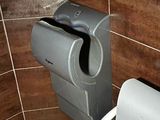 des toilettes dans une salle de bains, avec un distributeur de papier à côté
