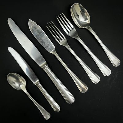 cinq fourchettes, une cuillère et un couteau posés sur une table noire